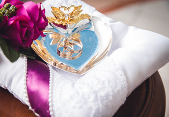 Designer wedding rings in the corner on a sparkling glitter background in panoramic banner format with copy space and selective focus