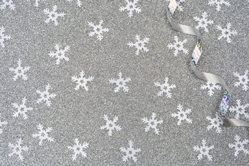 Beautiful Christmas card.White snowflakes and a shiny serpentine on a silver background with stars