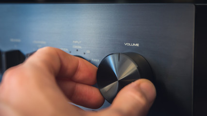 Hand turning a knob with output volume text written on it, with the consequence of a cost per unit...