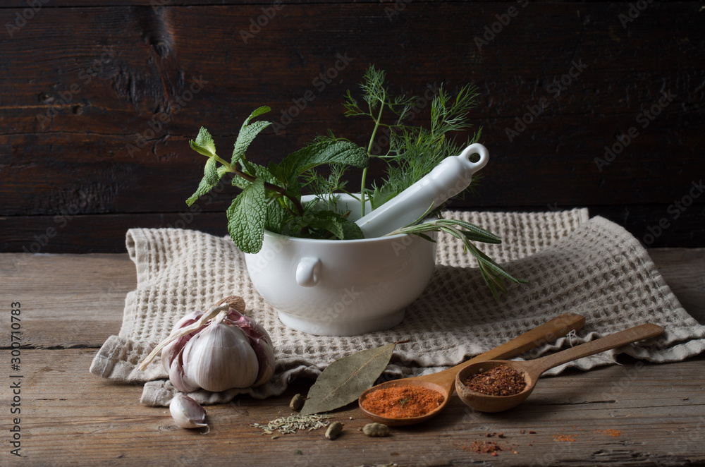 Wall mural Fresh spices thyme, turmeric, cardamom, basil, mint, parsley, dill  and rosemary on wooden background.