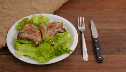 Roasted lamb chop served in a plate with lettuce