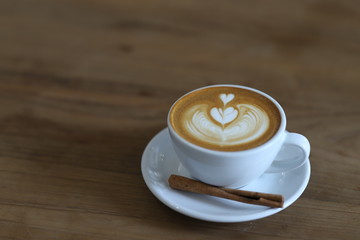 Cup of cappuccino with latte art on wooden background. Latte Coffee art on the wooden table. cup of coffee on table in coffee shop cafe