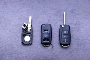 Broken or damaged remote key fob and new vehicle key on gray background. Broken or damaged remote key fob of any vehicle car service.- Image © AVC Photo Studio