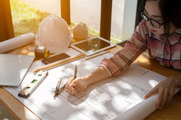Asia Young woman engineer working on blueprint in office. asian women engineer working on architects project. Young architect work project.