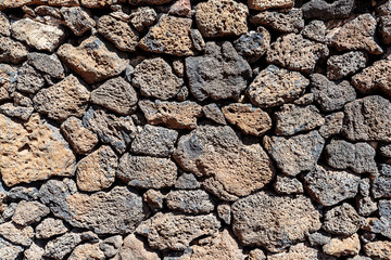 close-up shot of dry stone wall made of volcanic rocks background