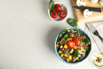 Flat lay composition with tasty buckwheat porridge on white wooden table, space for text