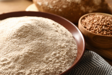 Bowl of buckwheat flour on table, closeup