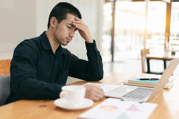 The man are stressed at work in the office. Asian businessman stressful and headache with laptop computer. Young male with headache at office, feeling sick at work.