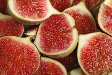 Tasty ripe cut fig fruits as background, closeup