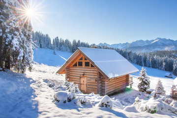 Winter mountain landscape. Wooden house in snowy mountains. Guest house in skiing resort. Snow...