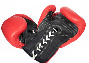 Red and black leather boxing gloves with white laces against a white background.