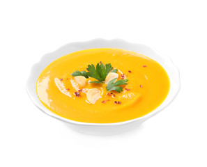 Delicious pumpkin soup in bowl on white background