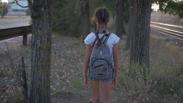 Danger near the road. A teenage girl walks along the railway, looks around and kills with fear.