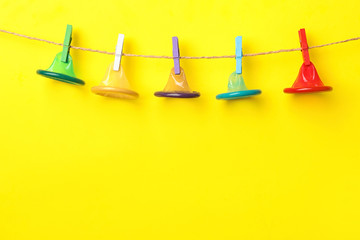 Colorful condoms hanging on clothesline against yellow background, space for text. Safe sex concept