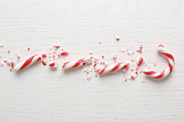 Crushed candy cane on white wooden background, flat lay. Traditional Christmas treat