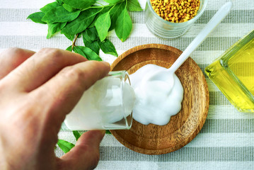 Topview hand mix apothecary ingredient cream on the table.