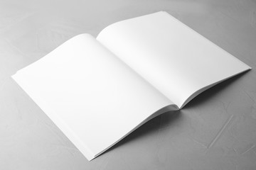 Blank open book on light grey stone background. Mock up for design
