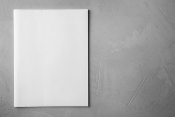 Blank book on light grey stone background, top view. Mock up for design