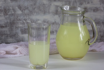 Jar and glass with liquid whey that remains after formation of curds on white background