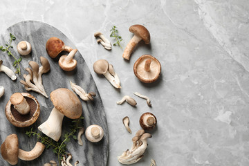 Flat lay composition with fresh wild mushrooms on light grey table