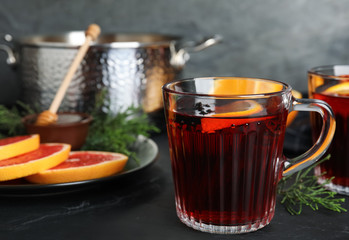 Tasty mulled wine and fresh ingredients on black table