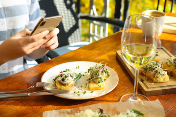 Food blogger taking photo of her lunch at cafe, closeup