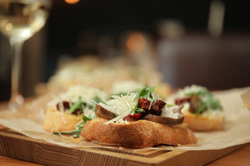 Delicious bruschettas with beef and cheese on table, closeup