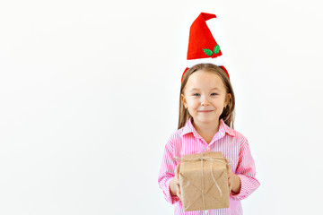 Christmas concept - Happy little girl smiling with gift box on white background with copy space