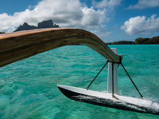 Sailing a boat around blue lagoon and luxury overwater villas at Bora Bora island, Tahiti, French...