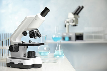 Modern microscope on table in laboratory, space for text. Medical equipment