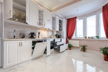 Luxury modern white kitchen interior with open doors and drawers