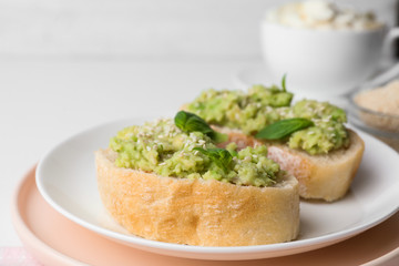 Plate with delicious avocado sandwiches on table