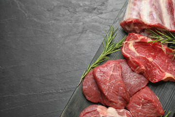 Fresh meat on black table, top view. Space for text