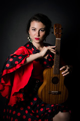 Obraz premium Carmen beautiful woman in red dress, with guitar on dark background