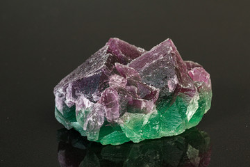 macro mineral stone green and purple fluorite on a black background