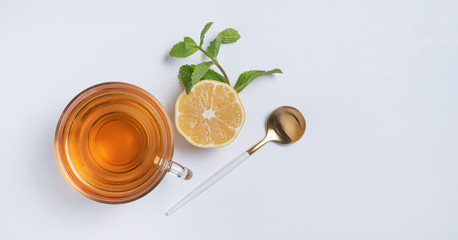 Cup of tea with lemon and mint on  white background. Top view and copy space