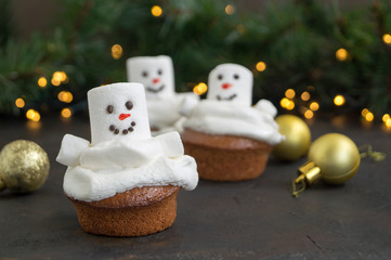 Christmas chocolate cupcakes with snowman decor. on dark background.