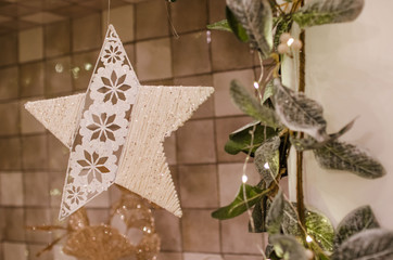  A beautiful Christmas bouquet of fir branches with colorful balls and flowers, a garland stands in the living room. Photo in warm tint.