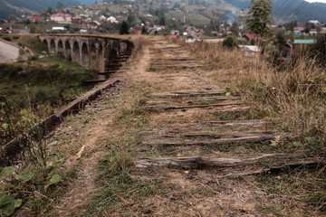 Fototapeta na wymiar Close view of old railroad tracks with worn ties. Railway viaduct Ukraine, Verkhovyna