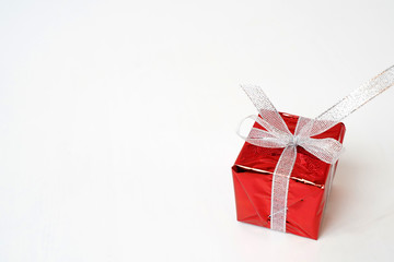 Beautiful red gift box with a silver bow on a white background. Copy space. Festive background