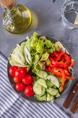 Different fresh vegetables on a plate. Diet and healthy food concept. Top view