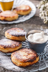 Obraz na płótnie Canvas Closeup photo of tasty cottage cheese pancakes with sour cream.