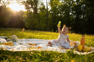 Little girl in a striped dress on a picnic in a city park.