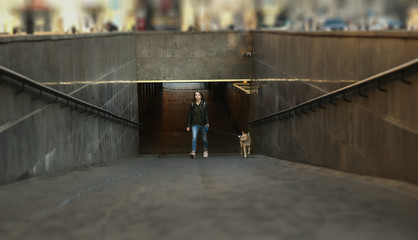 Young woman with dog at entrance of subway station