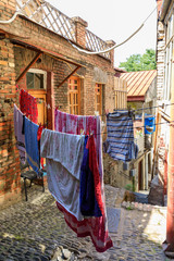 A typical georgian yard of an old traditional wooden house and clothes and linen drying on the ropes. Tbilisi Georgia, Caucasus mountains