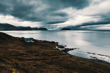 A small fishing hut on the seashore. Low thick clouds, gloomy mood. - 300728565