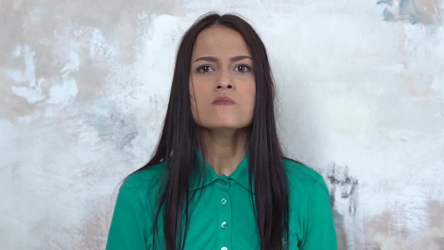 Young woman alone isolated on white wearing shirt restraining emotions