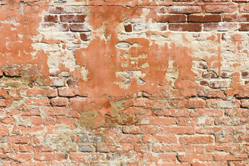 Brick wall pattern. Old wall built from the red bricks with remnants of plaster. Background texture.