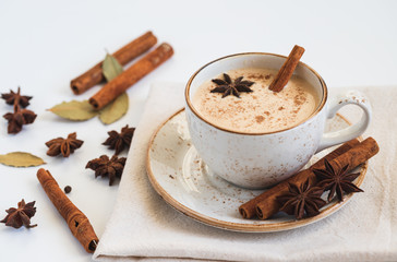 Indian Masala chai tea. Traditional Indian hot drink with milk and spices on white background closeup.