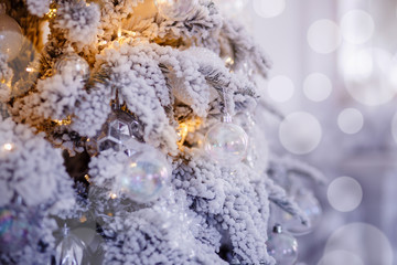 Christmas white tree decorated snow illumination and gifts toys, background light bokeh, silver color